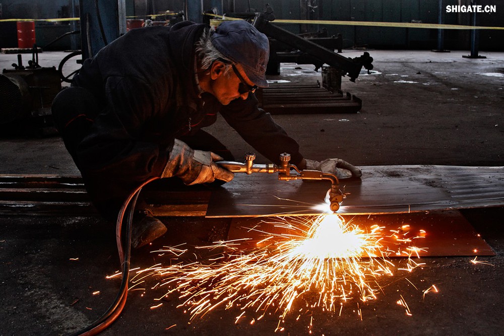 在工業(yè)生產(chǎn)中，鋼板切割是一項至關(guān)重要的工藝，廣泛應(yīng)用于機械制造、建筑、橋梁建設(shè)等多個領(lǐng)域。為了滿足不同項目的需求，鋼板切割采用了多種加工方式。本文將詳細介紹鋼板切割中常見的幾種加工方式，包括火焰切割、激光切割、等離子切割、水刀切割以及機械切割等。    一、火焰切割    火焰切割是利用氧氣和乙炔的燃燒產(chǎn)生的高溫火焰來切割鋼板的一種加工方式。在切割過程中，火焰將鋼板局部加熱至熔化狀態(tài)，同時氧氣流將熔化的金屬吹走，形成切口?；鹧媲懈钤O(shè)備相對簡單，成本低廉，適用于切割厚度較大的鋼板。然而，由于切割過程中產(chǎn)生的熱影響區(qū)較大，易導(dǎo)致鋼板變形和材質(zhì)變化，因此精度和表面質(zhì)量相對較低。          二、激光切割    激光切割是利用高功率密度的激光束照射鋼板表面，使鋼板迅速熔化、汽化或達到點燃點，同時以高速氣流將熔化或燃燒的金屬吹走，形成切口。激光切割具有切割速度快、精度高、熱影響區(qū)小等優(yōu)點，特別適用于切割薄板和中厚板。此外，激光切割還能實現(xiàn)自動化和智能化生產(chǎn)，提高生產(chǎn)效率。            三、等離子切割    等離子切割是利用高溫、高速度的等離子氣體流對鋼板進行切割的一種加工方式。在切割過程中，等離子氣體流將鋼板局部熔化，并通過氣流將熔化的金屬吹走。等離子切割適用于切割中厚板和厚板，具有切割速度快、熱影響區(qū)小、切口平整等優(yōu)點。然而，等離子切割設(shè)備的成本較高，維護也相對復(fù)雜。    四、水刀切割    水刀切割是利用高壓水流對鋼板進行切割的一種加工方式。在切割過程中，高壓水流將鋼板局部沖蝕，形成切口。水刀切割具有切割精度高、表面質(zhì)量好、無熱影響區(qū)等優(yōu)點，特別適用于切割薄板和對表面質(zhì)量要求較高的項目。此外，水刀切割還能實現(xiàn)綠色生產(chǎn)，減少環(huán)境污染。    五、機械切割    機械切割是利用切割機械對鋼板進行切割的一種加工方式，如鋸床切割、銑床切割等。機械切割適用于切割各種厚度和材質(zhì)的鋼板，具有切割精度高、切口平整、適應(yīng)性強等優(yōu)點。然而，機械切割的速度相對較慢，生產(chǎn)效率較低，且對于較厚的鋼板，切割難度較大。            在選擇鋼板切割加工方式時，需要根據(jù)項目的具體需求、鋼板的厚度和材質(zhì)、生產(chǎn)效率和成本等因素進行綜合考慮。對于要求高精度、高表面質(zhì)量的切割項目，激光切割和水刀切割是較為理想的選擇；對于切割厚度較大、對表面質(zhì)量要求不高的項目，火焰切割和等離子切割則更具優(yōu)勢；而對于需要靈活應(yīng)對各種切割需求的場景，機械切割則是一種可靠的選擇。    總之，隨著科技的不斷進步和工業(yè)生產(chǎn)的不斷發(fā)展，鋼板切割加工方式也在不斷創(chuàng)新和完善。了解各種加工方式的優(yōu)缺點，并根據(jù)實際需求選擇合適的加工方式，對于提高鋼板切割的質(zhì)量和效率具有重要意義。